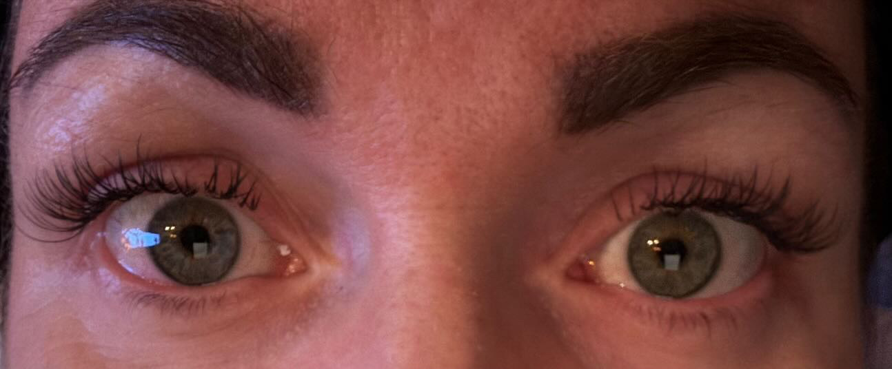 Twee ogen met wimperextensions en verzorgde wenkbrauwen